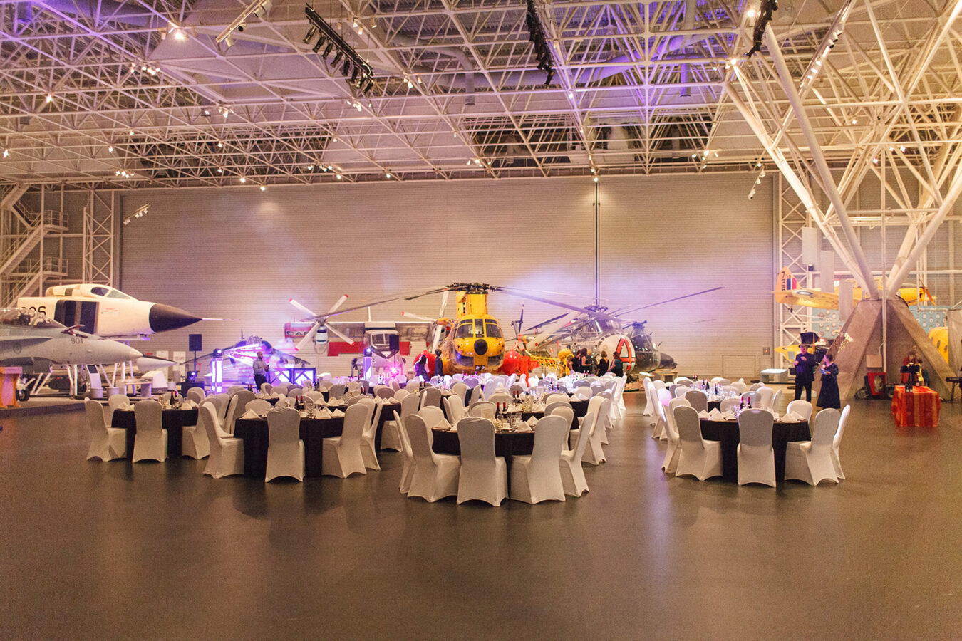white tables set up for a wedding at the aviation museum in Ottawa