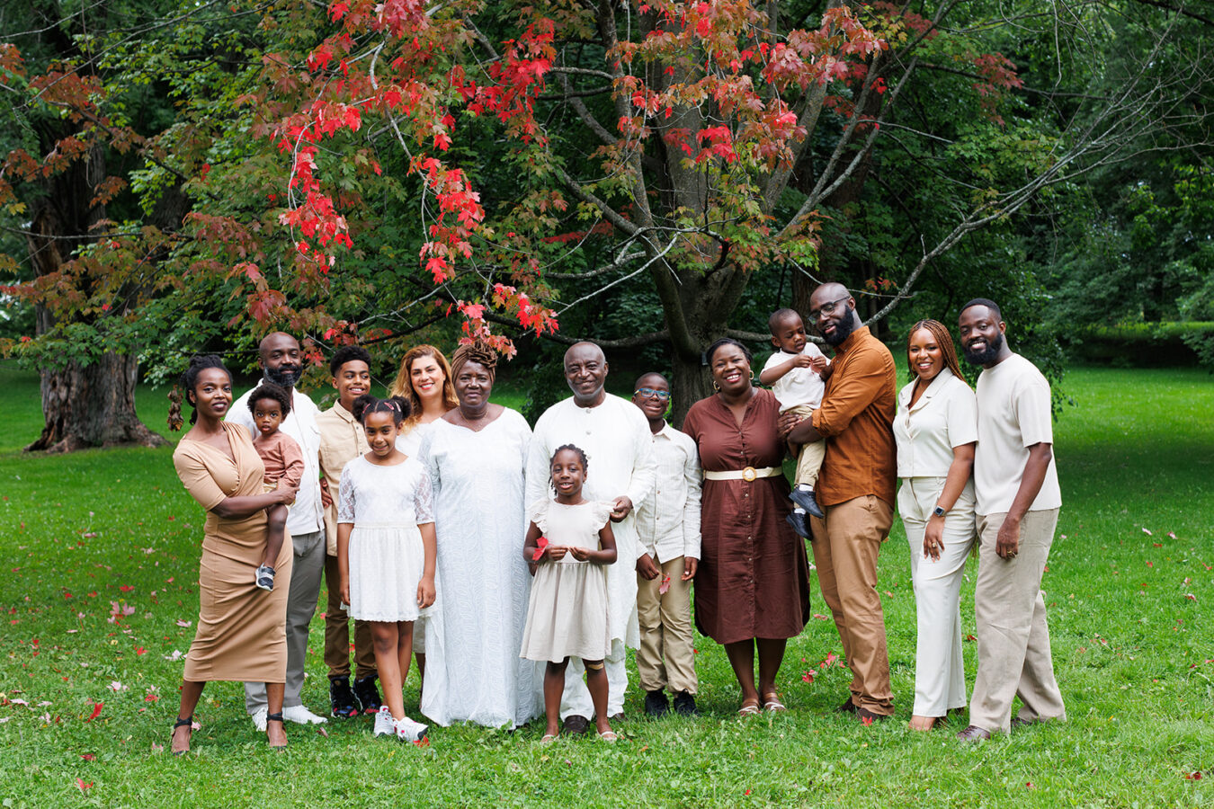 Extended family of 15 under red-leaved tree at arboretum