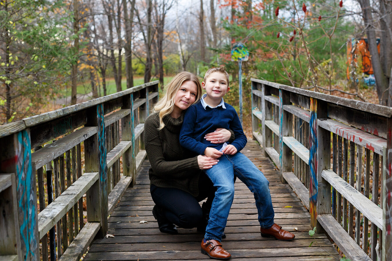 Mom and son on footbridge, mom in green textured sweater