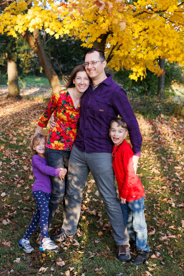 Family wearing bright purple and red outfits for fall photos